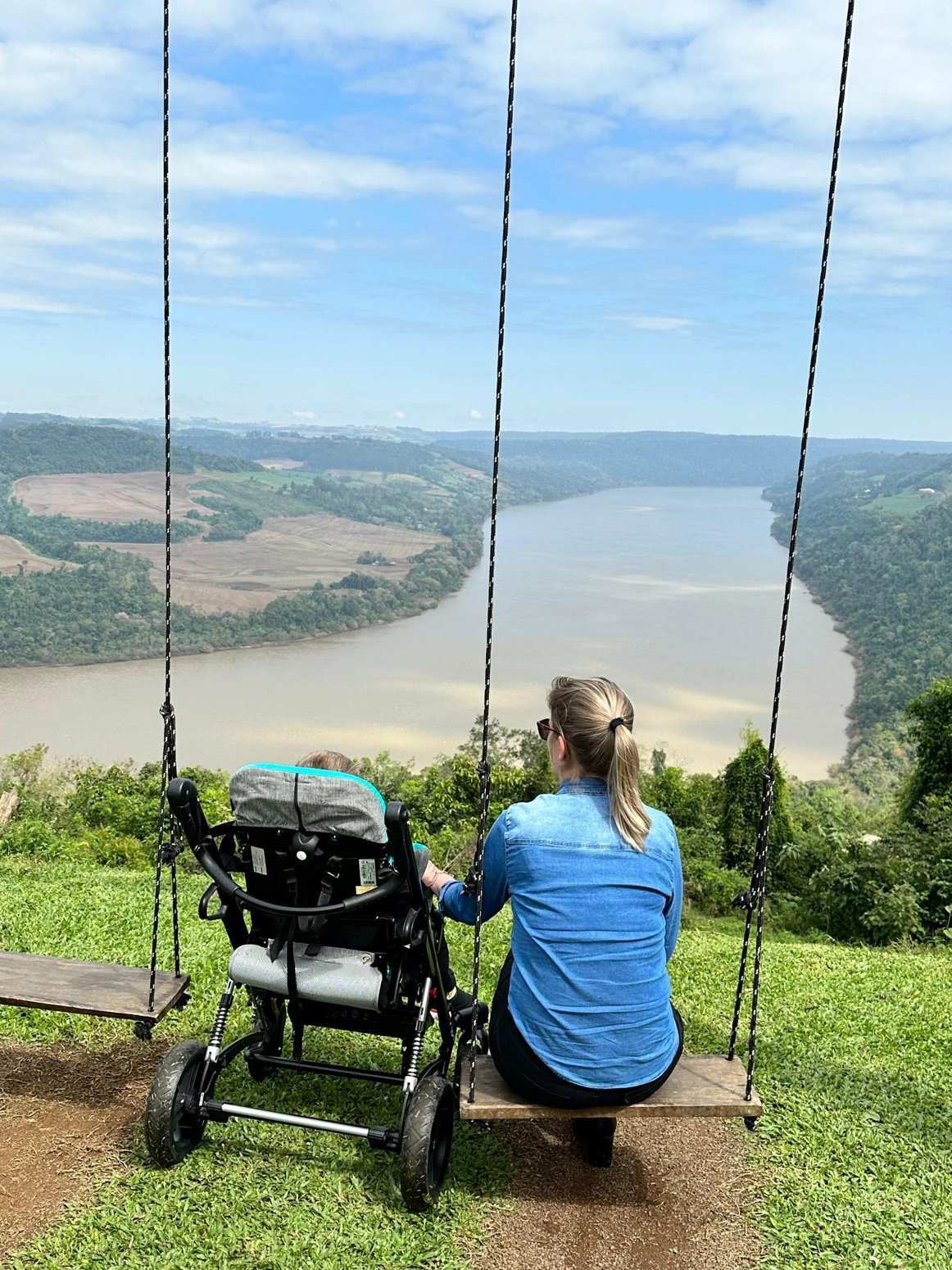 Denise e Miguel juntos diante de uma paisagem